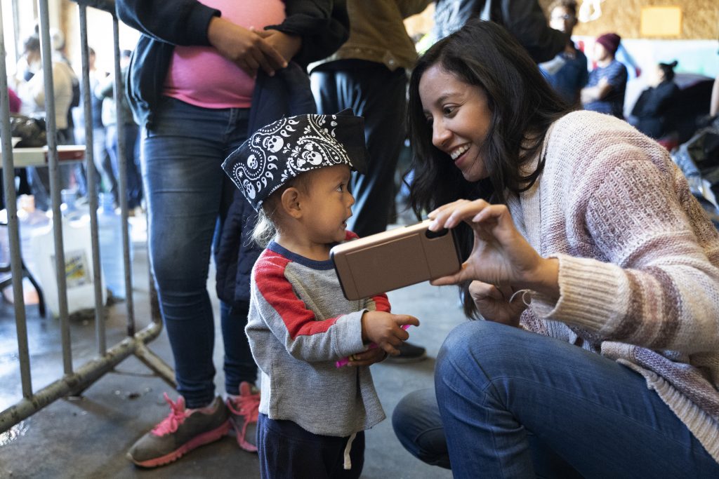 A humanitarian activist plays with a child at an immigrant shelter in Tijuana.