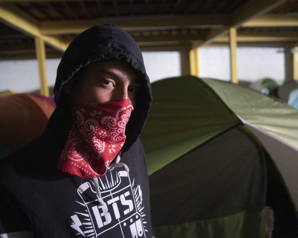 A detainee at the Mexican border wears a bandana to cloak his identity.