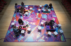 People studying on colorful floor mat. Photo by Leo March, mneyid.com