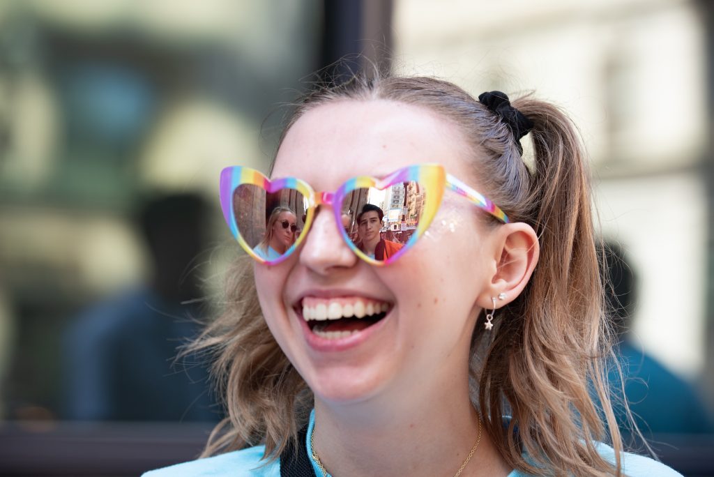 A student smiles while wearing sunglasses
