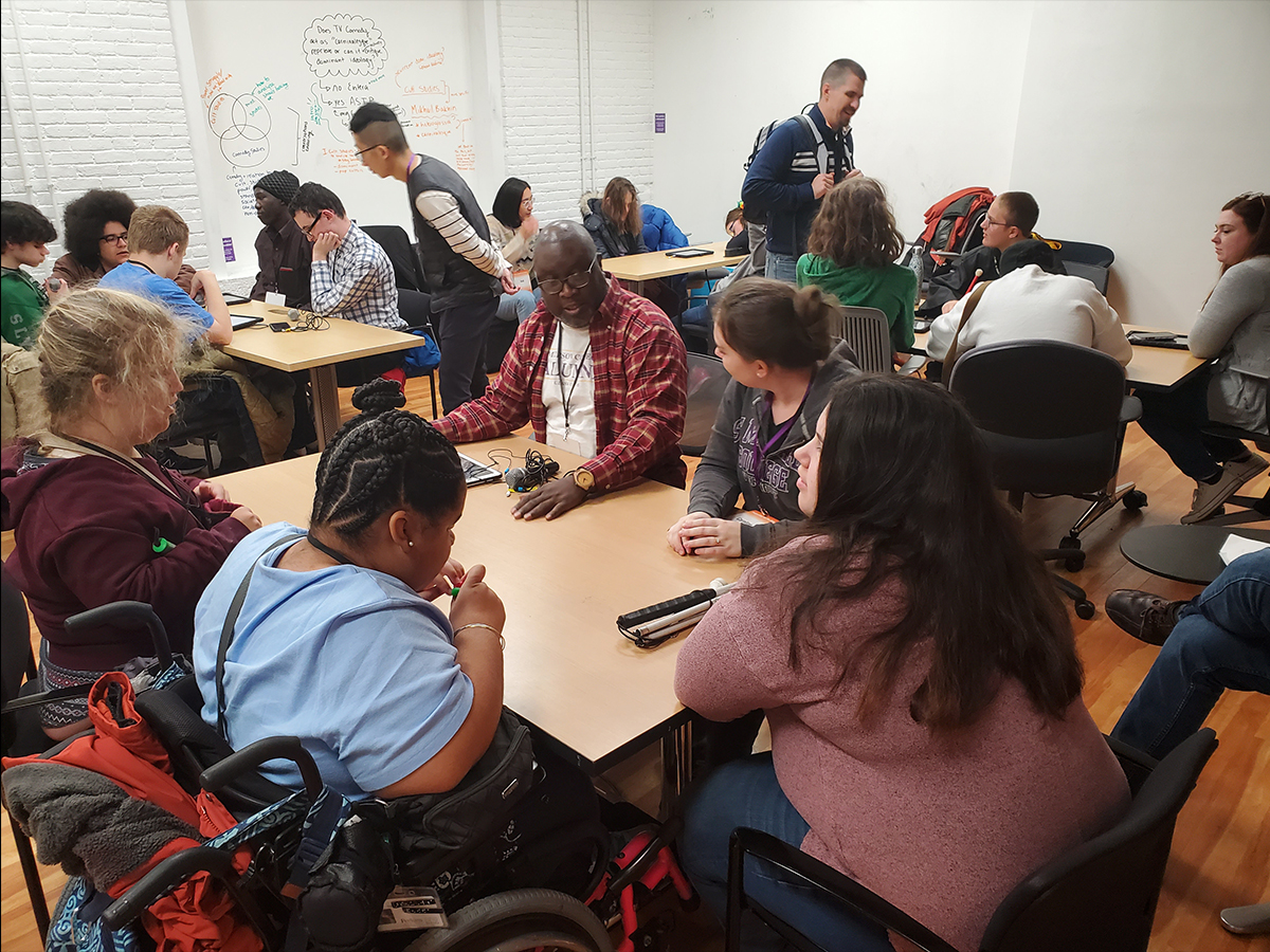 This image shows Emerson Communication Studies students working with high school students who are blind to help them learn podcasting.