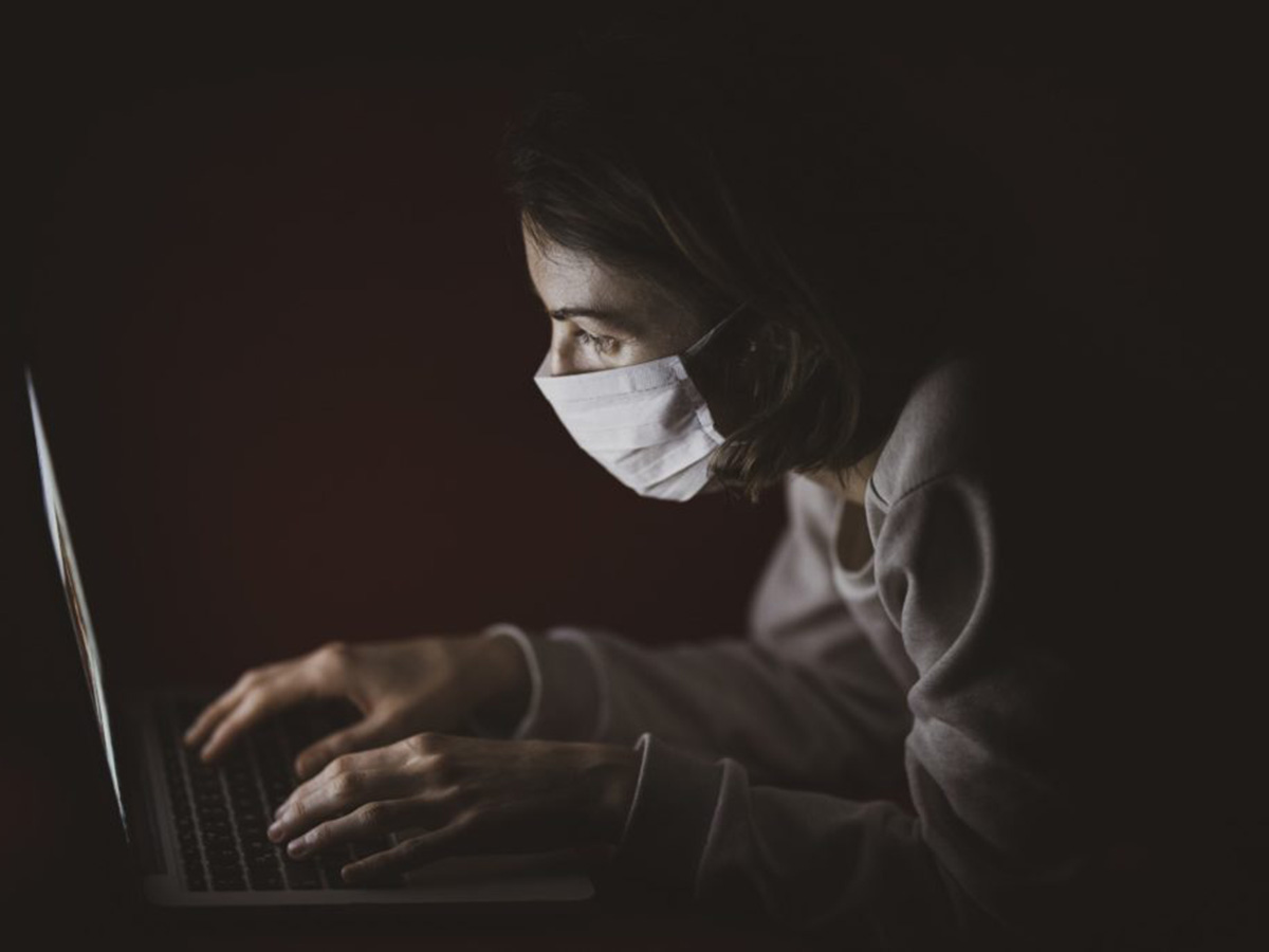 woman in mask typing
