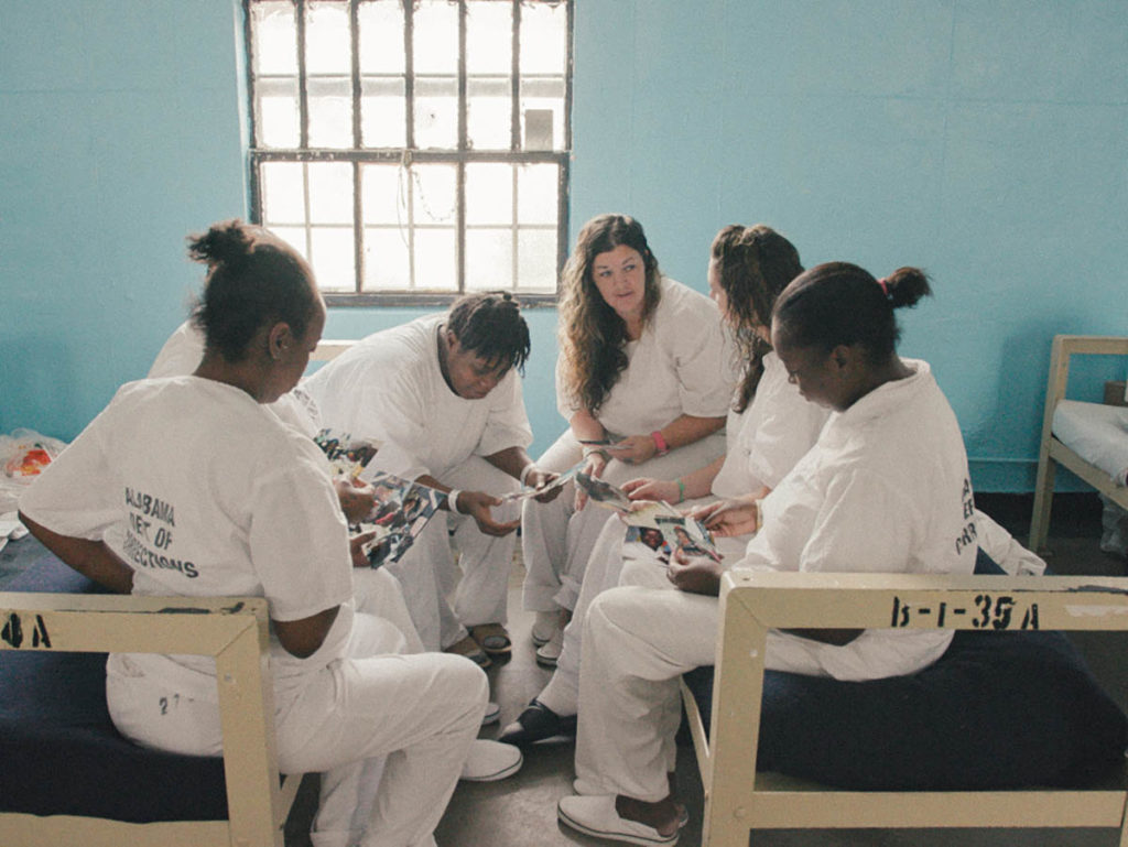 Five incarcerated women sit together.