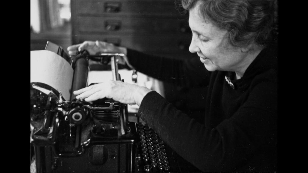 A woman touches a typewriter