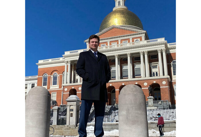 Man stands in front of Massachusetts State House