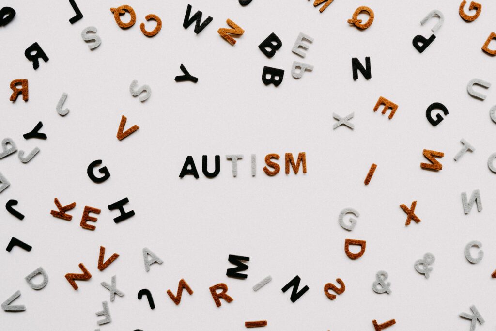 graphic of scattered letters, with six in the middle spelling autism