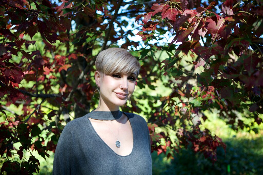 Headshot of woman standing in front of leaves of a tree