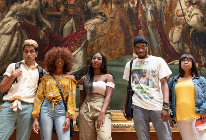 Five black students in front of a painting in the Louvre