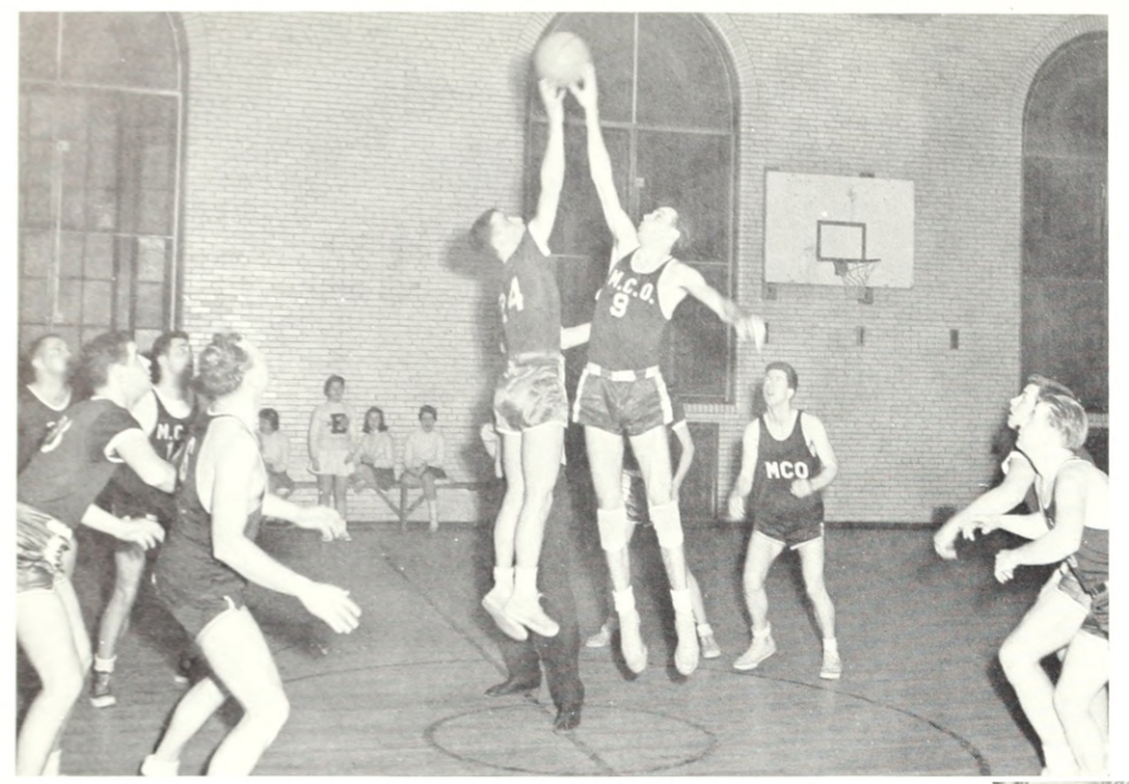 Men's basketball game with two men jumping for ball
