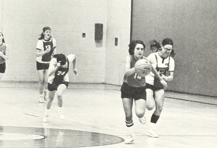 black and white photo of women playing basketball