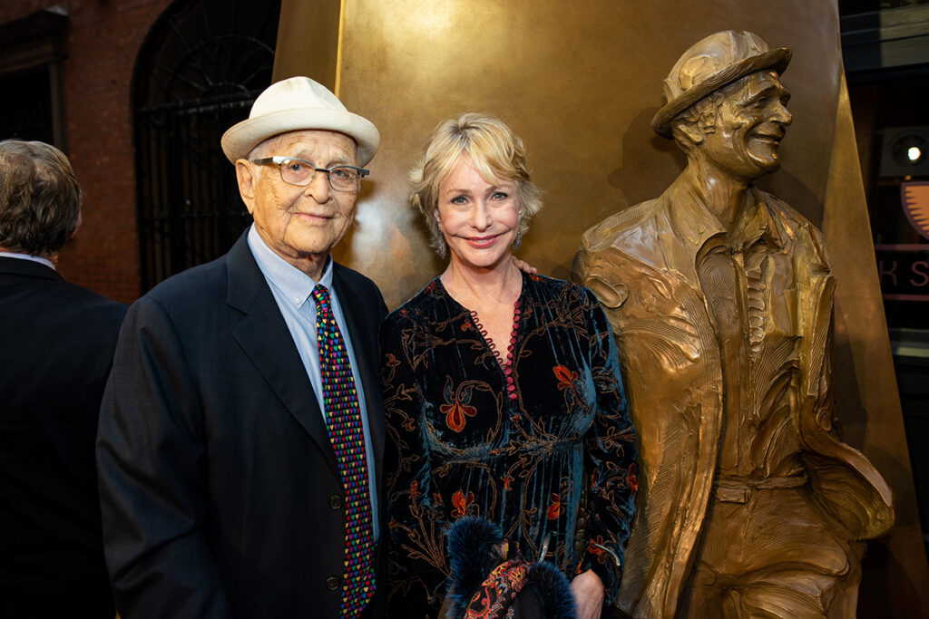 Norman and Lyn Davis Lear in front of statue of Norman