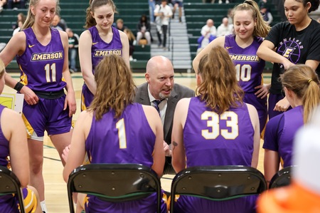 coach talks to women's basketball team on court