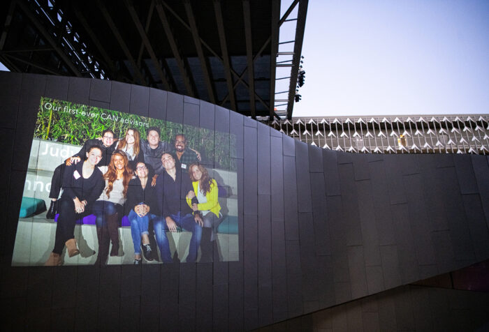 Photo of advisors and students projected onto steel wall at ELA