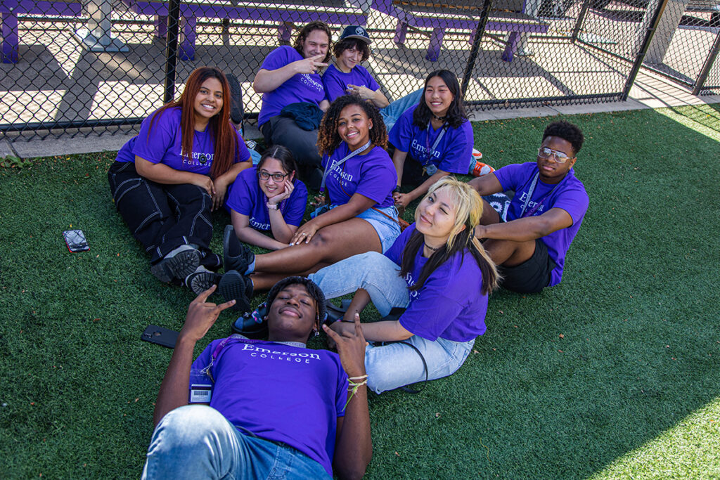 students in purple Ts sitting on ground looking up