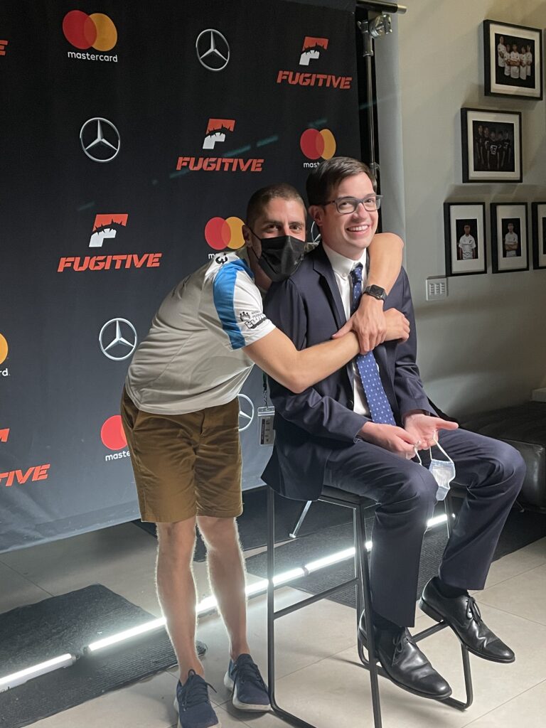 Tony Yacenda hugs Dan Perrault while Perrault is sitting