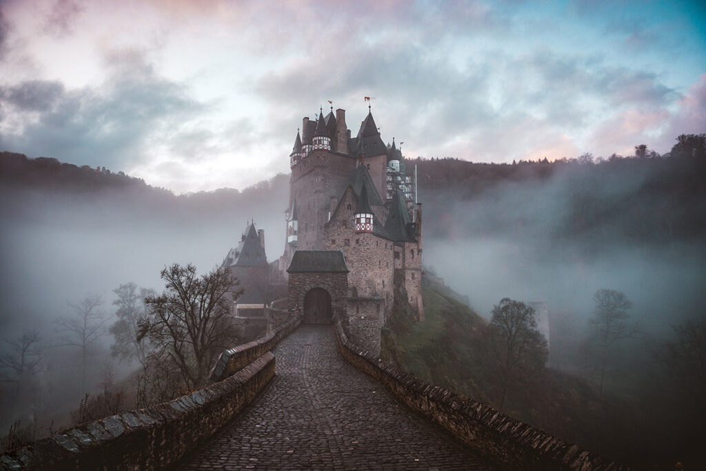 Gothic castle in the mountains and fog