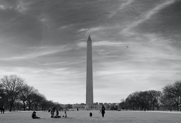 black and white photo of Washington Monument with people milling about in foreground