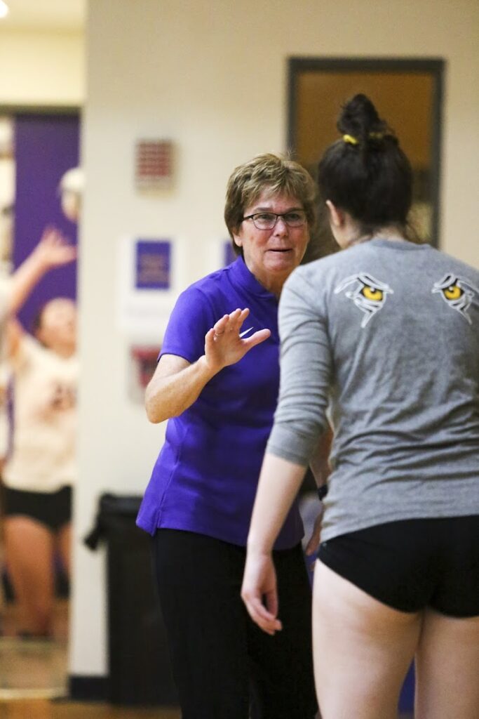 Pat Nicol talks to a women's volleyball player
