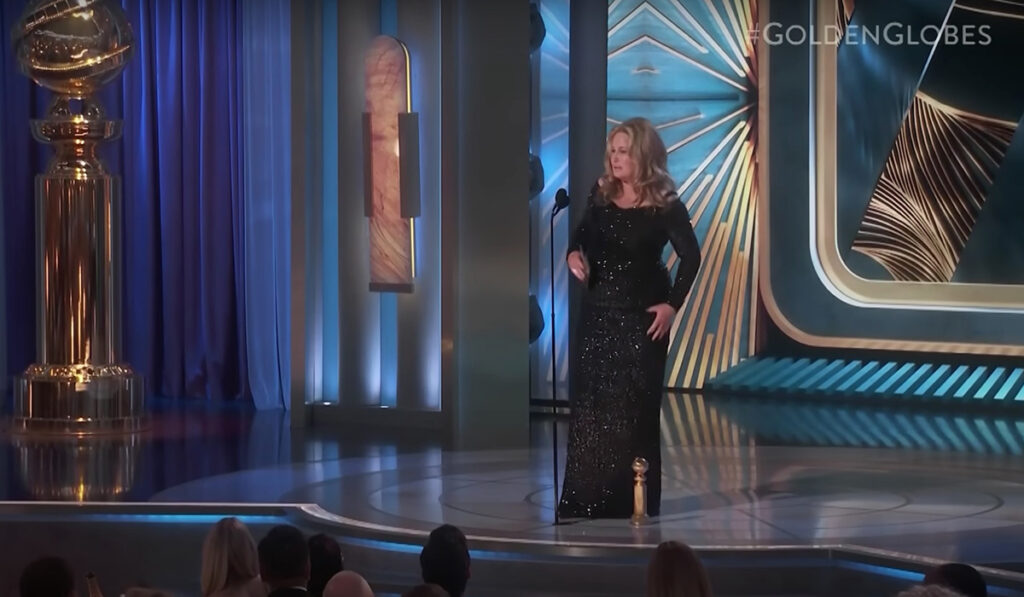 screen shot of Jennifer Coolidge on Golden Globes stage with giant statue of Golden Globe award