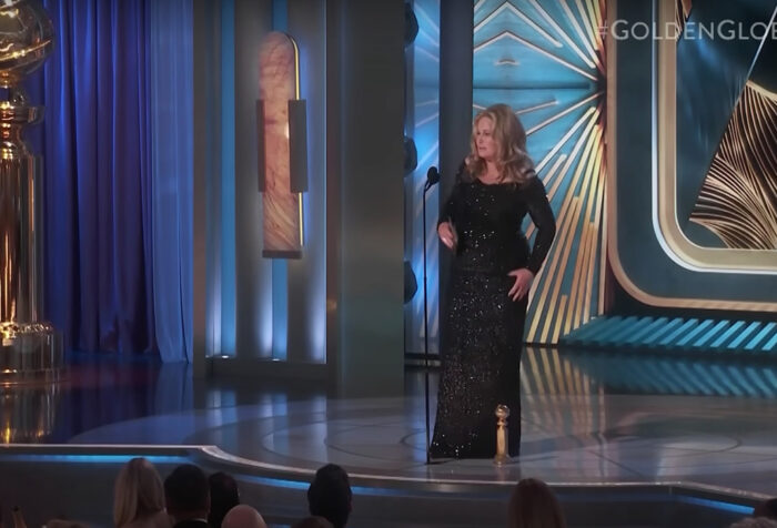 screen shot of Jennifer Coolidge on Golden Globes stage with giant statue of Golden Globe award
