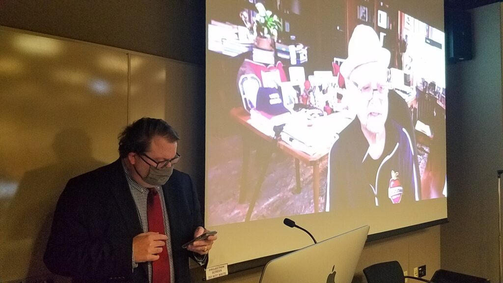 A large projection screen shows Norman Lear live, zooming in Tripp Whetsell's class