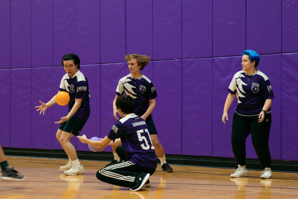 One person tries to catch a dodgeball while their three teammates watch