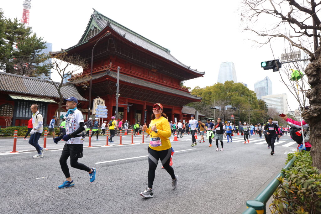 Nydia Bou runs the Tokyo Marathon with Zōjō-ji Temple behind her