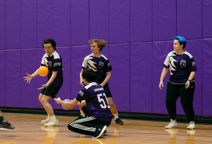 One player tries to catch the ball while his teammates watch in anticipation