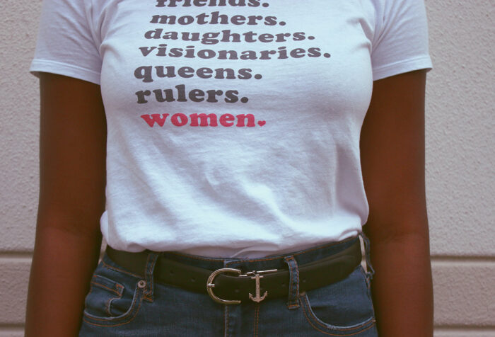 close up of woman's torso wearing T-shirt reading "friends, mothers, daughters, visionaries, queens, rulers, women"
