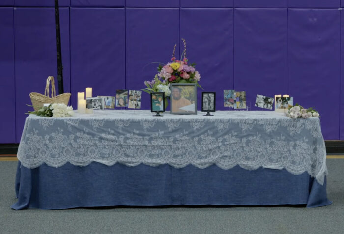 Altar covered in blue cloth, lace, covered in photos of Brooks and flowers