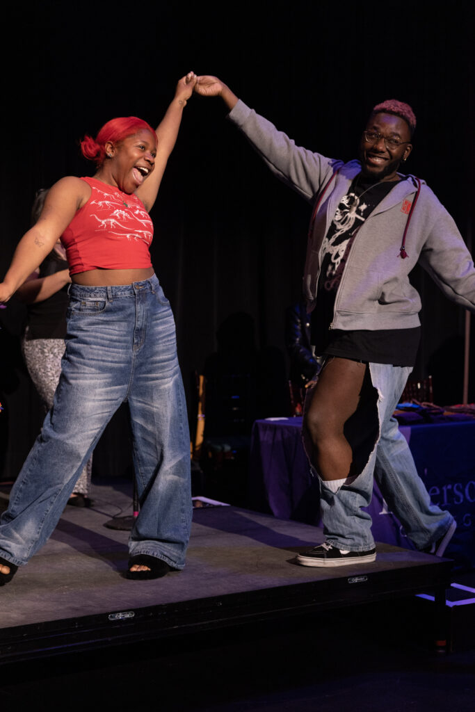 Two people dance across the stage