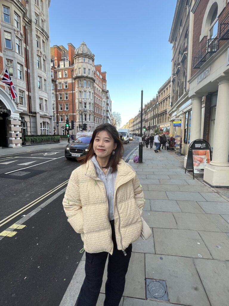 Jianyi standing on what looks like a London street