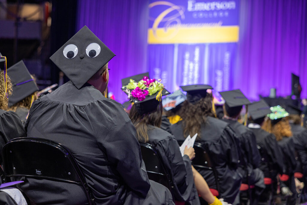 back of graduates heads, one mortarboard has googly eyes pasted on