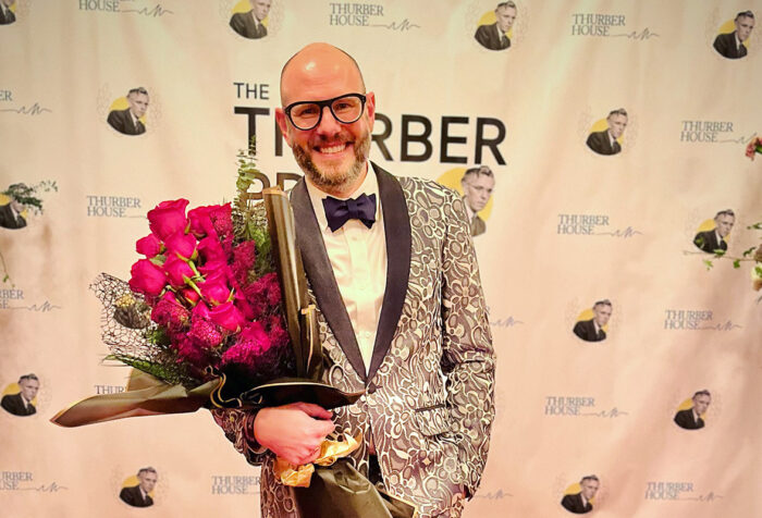 Steven Rowley, wearing a tuxedo, holds a bouquet