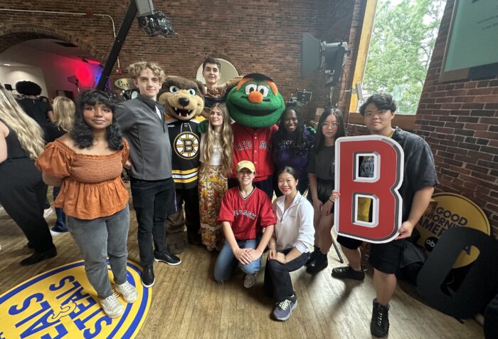 A group of people gather with two mascots.