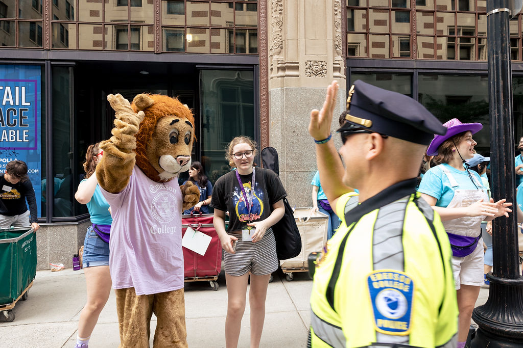 Griff the mascot high fives a police officer