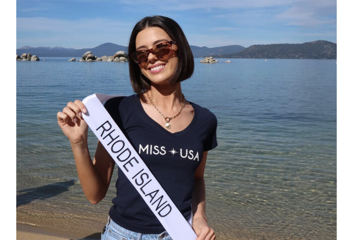 Mary Malloy holds her Miss Rhode Island sash in front of a body of water