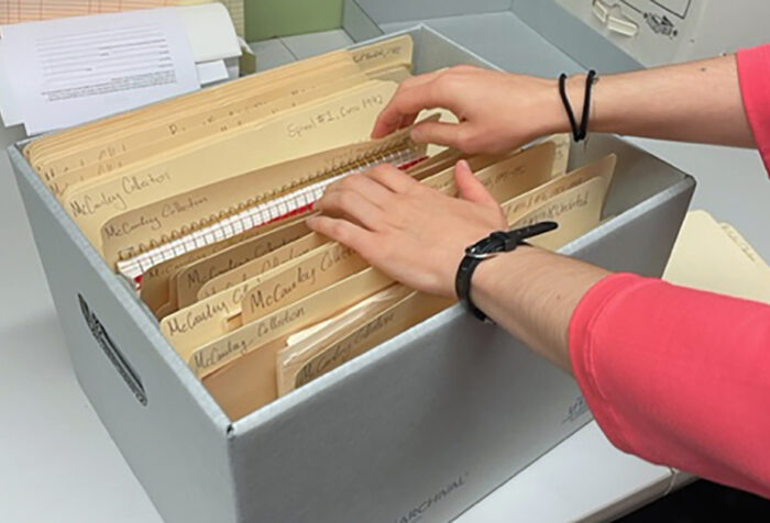 A staff member reviews a recently arranged box from the Robbie McCauley Collection
