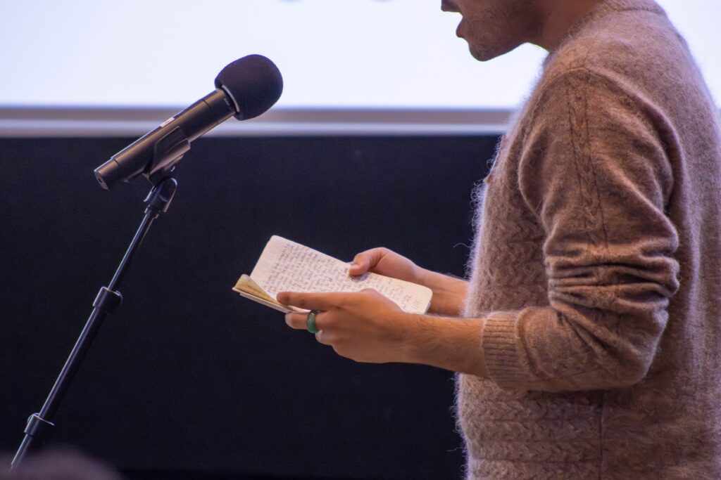Close-up of someone holding a notebook while speaking
