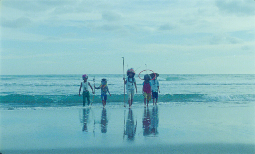 Five children walk away from the ocean
