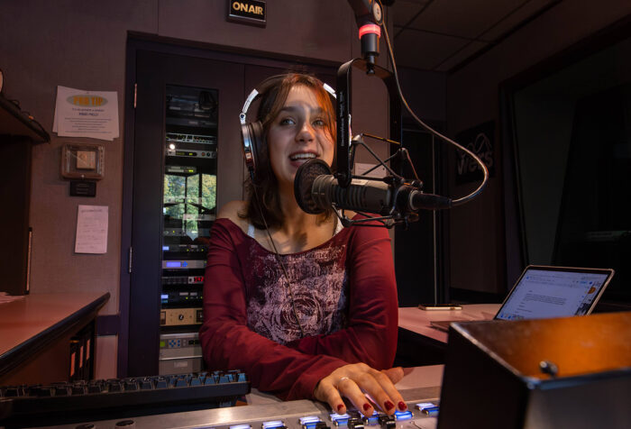 Isabella Mitchell announces on-air in front of microphone