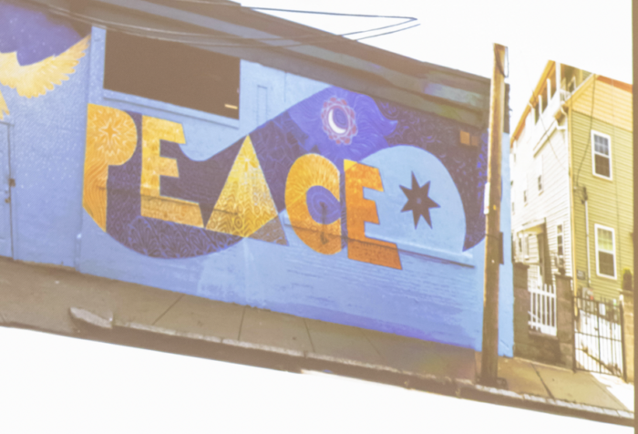Photo of a mural that says: peace