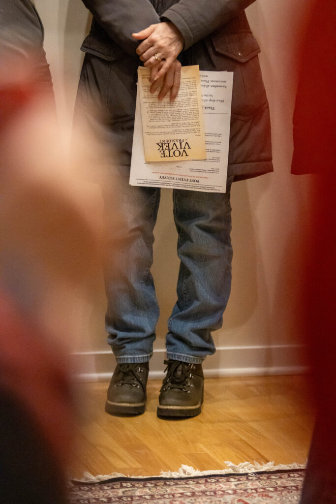 From the waist down, a person holds a voting slip at the Iowa Caucus