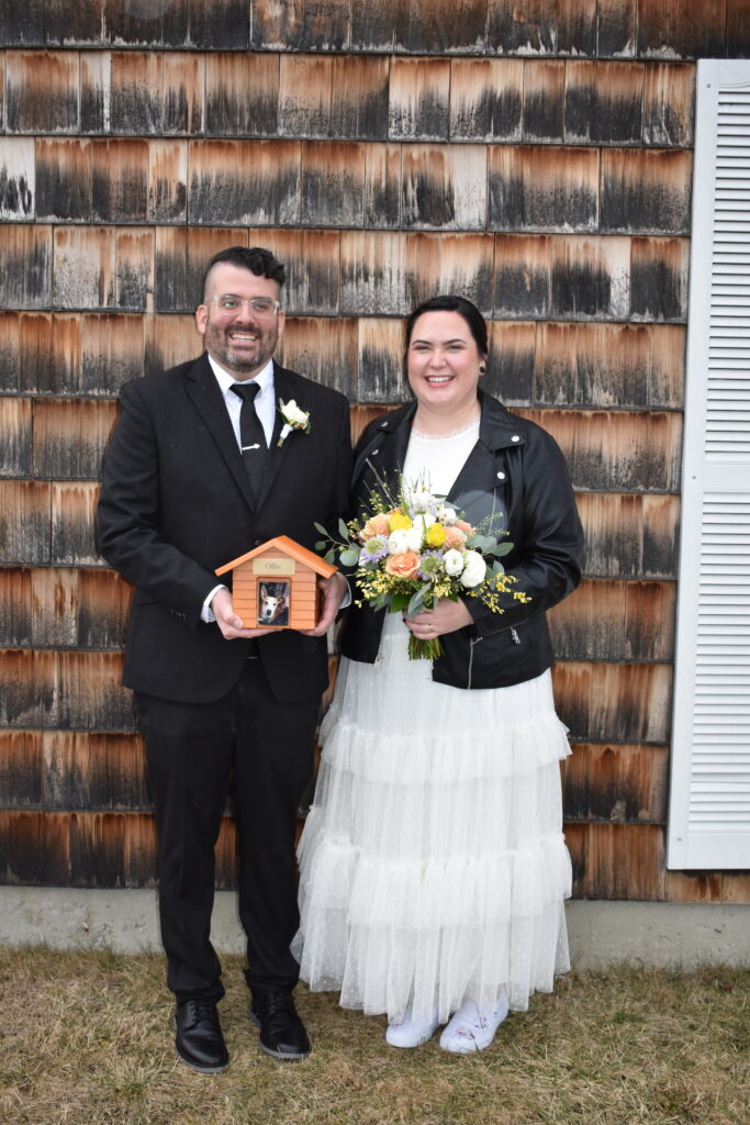Sean Bennett and Shannon Murphy on their wedding. He's holding a bird house and she's holding a bouquet.