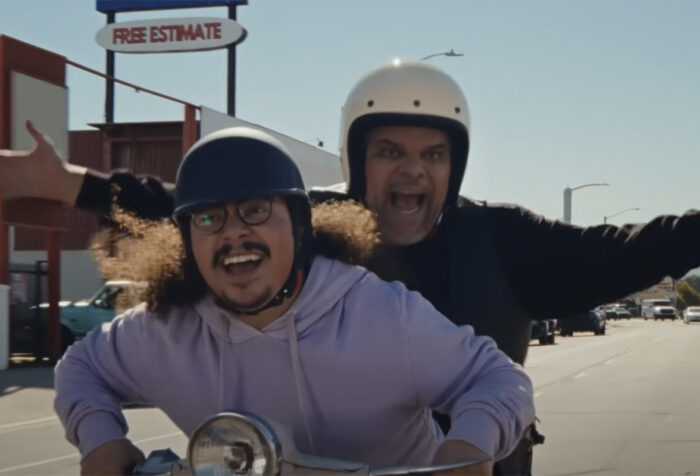Andrew Santiago drives a scooter with Luis Guzman on the back
