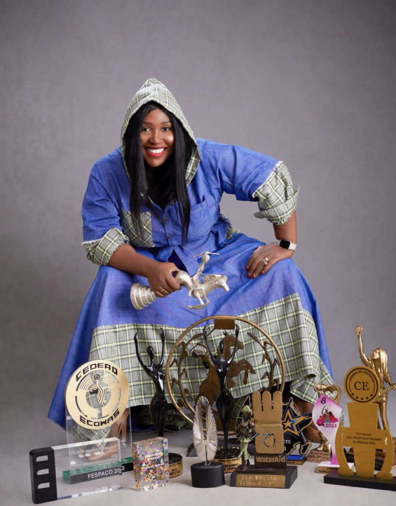 Apolline Traoré sits with numerous movie awards in front of her