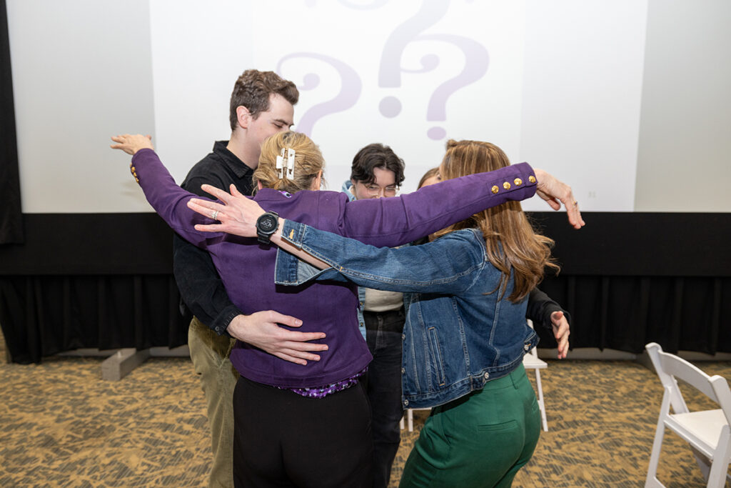 Five people hug in a circle