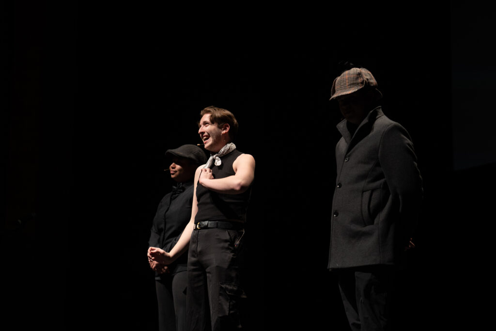A person performs with two people standing next to them