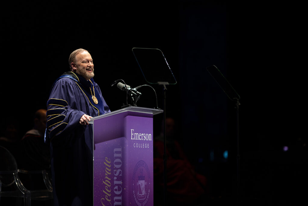 man in purple robes speaks at purple podium