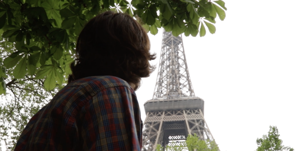 A person looks up to the Eiffel Tour